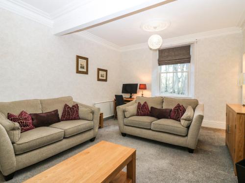 a living room with two couches and a table at Mavisbank in Peterhead