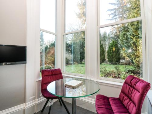 a living room with a glass table and two chairs at Mavisbank in Peterhead