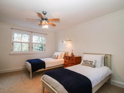 a bedroom with two beds and a ceiling fan at Mavisbank in Peterhead