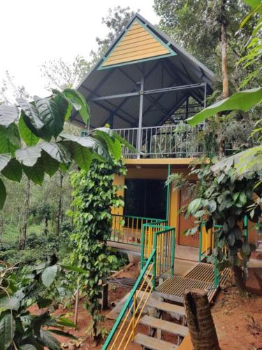 a small house with a porch and a balcony at Mistvalley Hut in Chithragiri