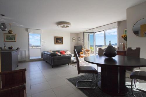 un salon avec une table et un canapé dans l'établissement Apt - terrace panoramic view and wifi, à Aix-en-Provence