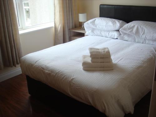 a bedroom with a bed with two towels on it at Sun Apartments in Enniscrone