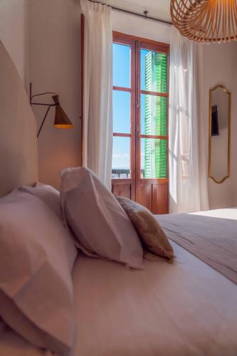 a bedroom with a bed with pillows and a window at CANDIL SUITE Realejo in Granada