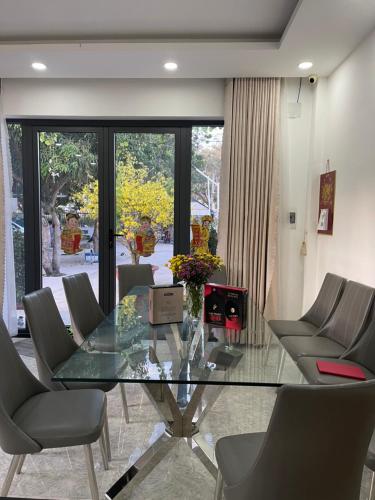 a dining room with a glass table and chairs at Mango Villa Long Hải Beach in Long Hai