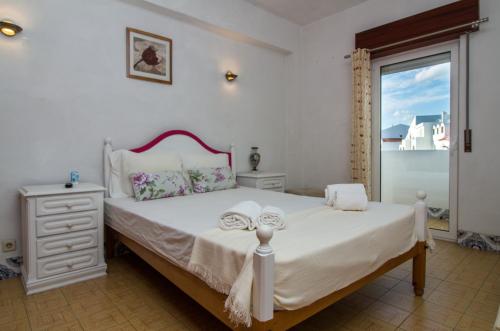 a bedroom with a large white bed with a window at Ocean View Apartment - Pool and Sea View & Albufeira Center in Albufeira