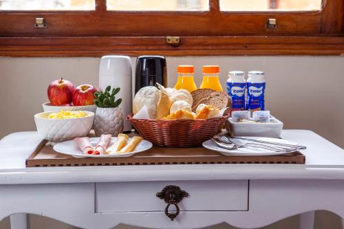 a tray with bread and other foods on a table at Hotel Gambrinus in Poços de Caldas
