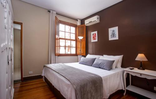 a bedroom with a large bed and a window at Hotel Gambrinus in Poços de Caldas
