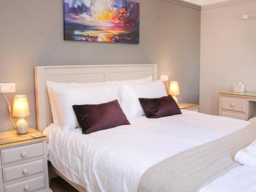 a bedroom with a large white bed with two pillows at The Little Dingle in Church Stretton