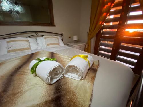een slaapkamer met een bed met handdoeken erop bij Alloggio turistico La Maison de Matì in Monterotondo