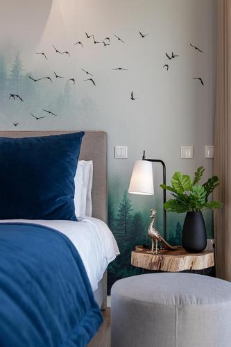 a bedroom with a bed with birds on the wall at The Cliffhouse by LovelyStay in Fajã da Ovelha