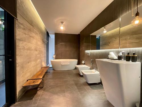 a bathroom with two toilets and a tub and a sink at La Villa Da Lat in Khu Chi Lăng