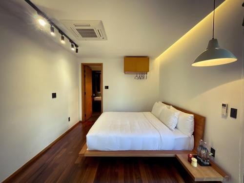 a bedroom with a white bed in a room at La Villa Da Lat in Khu Chi Lăng
