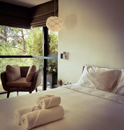 a bedroom with a bed and a chair and a window at La Villa Da Lat in Khu Chi Lăng