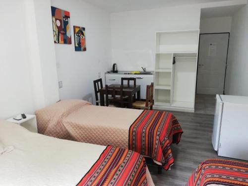 Habitación de hotel con 2 camas y cocina en Guest House Salta en Salta