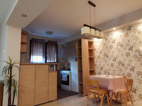 a kitchen and dining room with a table and chairs at Hills Apartment in Niš