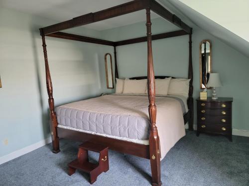 a bedroom with a canopy bed and a dresser at Lowell Inn in Stillwater