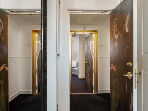 a hallway with a mirror in a room at Hotel Colón Gran Meliá - The Leading Hotels of the World in Seville
