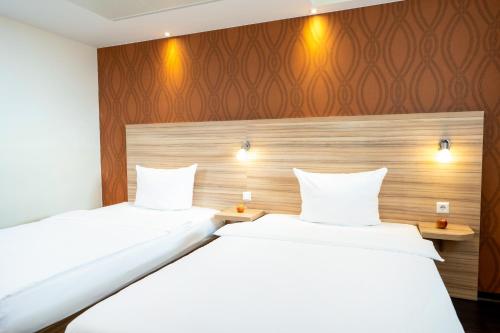 A bed or beds in a room at Messe & Airport Hotel Stuttgart