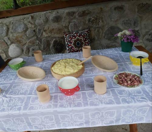 a table with a white table cloth with food on it at Etno Konak MB in Kolašin