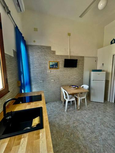 a living room with a table and a refrigerator at Il Muretto in Marettimo