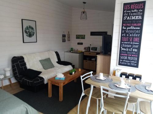 een woonkamer met een bank en een tafel bij O Douceurs Sucrées Cabourg in Cabourg