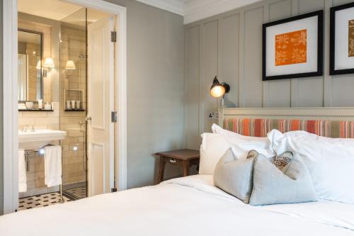 a bedroom with a white bed and a sink at King Street Townhouse in Manchester