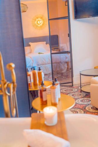 a room with a bed and a table and a mirror at CANDIL SUITE Realejo in Granada
