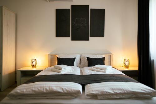 a bedroom with a large bed with two lamps at Munkácsy Villa - Szekszárd in Szekszárd