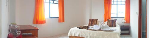 a bedroom with a bed with shoes on it at Arena Blanca Eco Hotel in Puerto Baquerizo Moreno