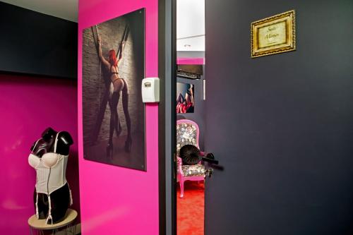 une porte rose avec une photo d'une femme dansante dans l'établissement SUITE MIROIRS Love Hotel Toulouse, à Toulouse