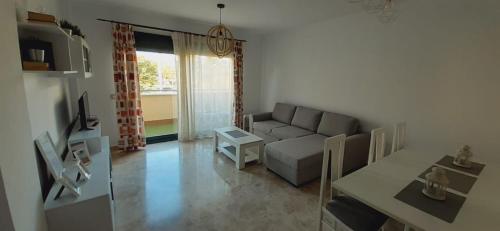 ein Wohnzimmer mit Sofa und Tisch in der Unterkunft LyriosHomes Beach Costa Ballena in Chipiona