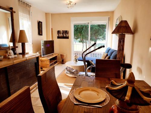 uma sala de estar com uma mesa e cadeiras e uma televisão em Indo Loma Sancti Petri em Chiclana de la Frontera