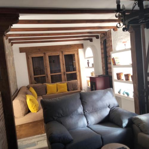 a living room with a couch with yellow pillows at Casa Rural El Arroyo in Sotoserrano