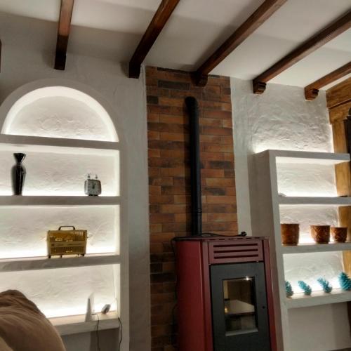 a room with a stove in a room with shelves at Casa Rural El Arroyo in Sotoserrano