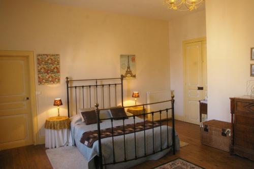 - une chambre avec un lit et deux lampes sur les tables dans l'établissement L'Impasse du Temple, à Léran