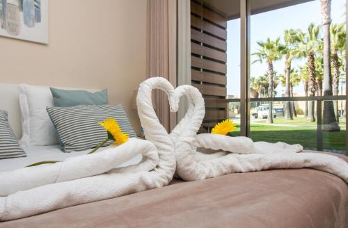een bed met twee zwanen gemaakt van handdoeken bij Anchor Apartment - Herdade dos Salgados & Luxurious & 7 Pools & Golf in Albufeira