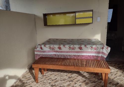 a wooden bench in a room with a window at Sobrado aconchegante in Ilhéus