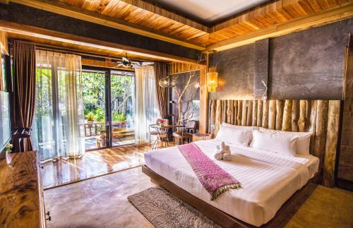 a bedroom with a bed with a cat sitting on it at Andalay Beach Resort Koh Libong in Ko Libong