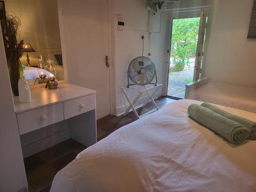 sypialnia z dużym białym łóżkiem i oknem w obiekcie Rosenhof Garden Cottage w mieście Clanwilliam