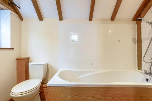 a bathroom with a toilet and a bath tub at Shire Cottage in Broadway