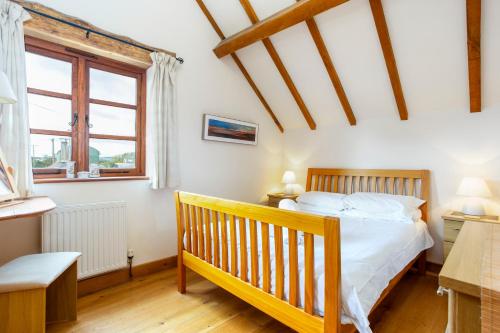 a bedroom with a wooden bed and a window at Shire Cottage in Broadway
