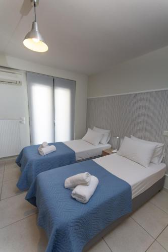 two beds in a room with towels on them at Spacious Fully Equipped 3BD 2Bath Apt in the heart of city with Balconies AC and fast WIFI #1 in Heraklio Town