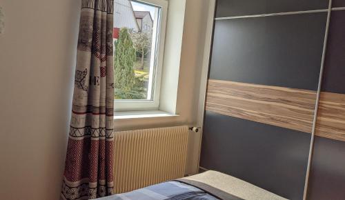 a bedroom with a window and a bed with a radiator at Wohlfühlmomente im Nordschwarzwald in Pfalzgrafenweiler