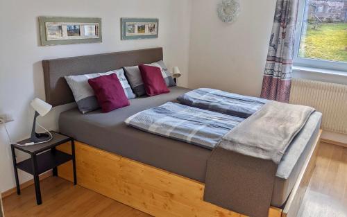 1 dormitorio con 1 cama grande con almohadas moradas en Wohlfühlmomente im Nordschwarzwald, en Pfalzgrafenweiler