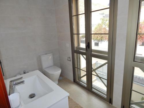 a white bathroom with a toilet and a sink at 5 bedrooms Villa Costa Adeje in Adeje