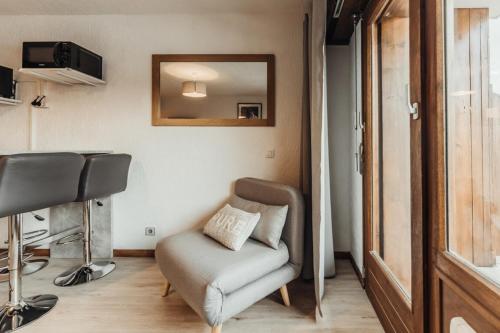 een salon met een stoel en een spiegel in een kamer bij Furnished studio on the ski slopes with a terrace & panoramic views in Saint-Gervais-les-Bains