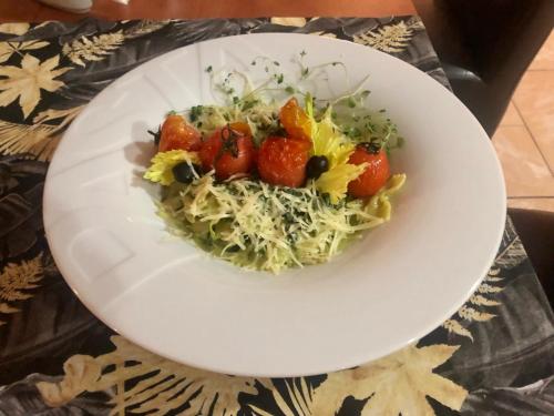 a white plate of food with strawberries and cabbage at Sosnowe Zacisze in Białystok