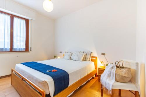 - une chambre avec un lit et une chaise dans l'établissement Appartamento Alba Rosa 5 - MyHo Casa, à Alba Adriatica