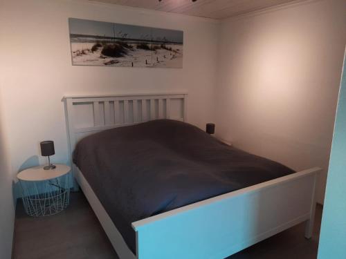 1 dormitorio con 1 cama y mesa auxiliar en Holiday Nr,3, en Immenstedt