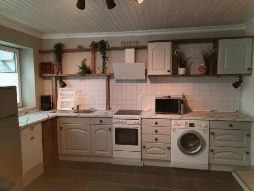 a kitchen with a stove and a washing machine at Holiday Nr,3 in Immenstedt